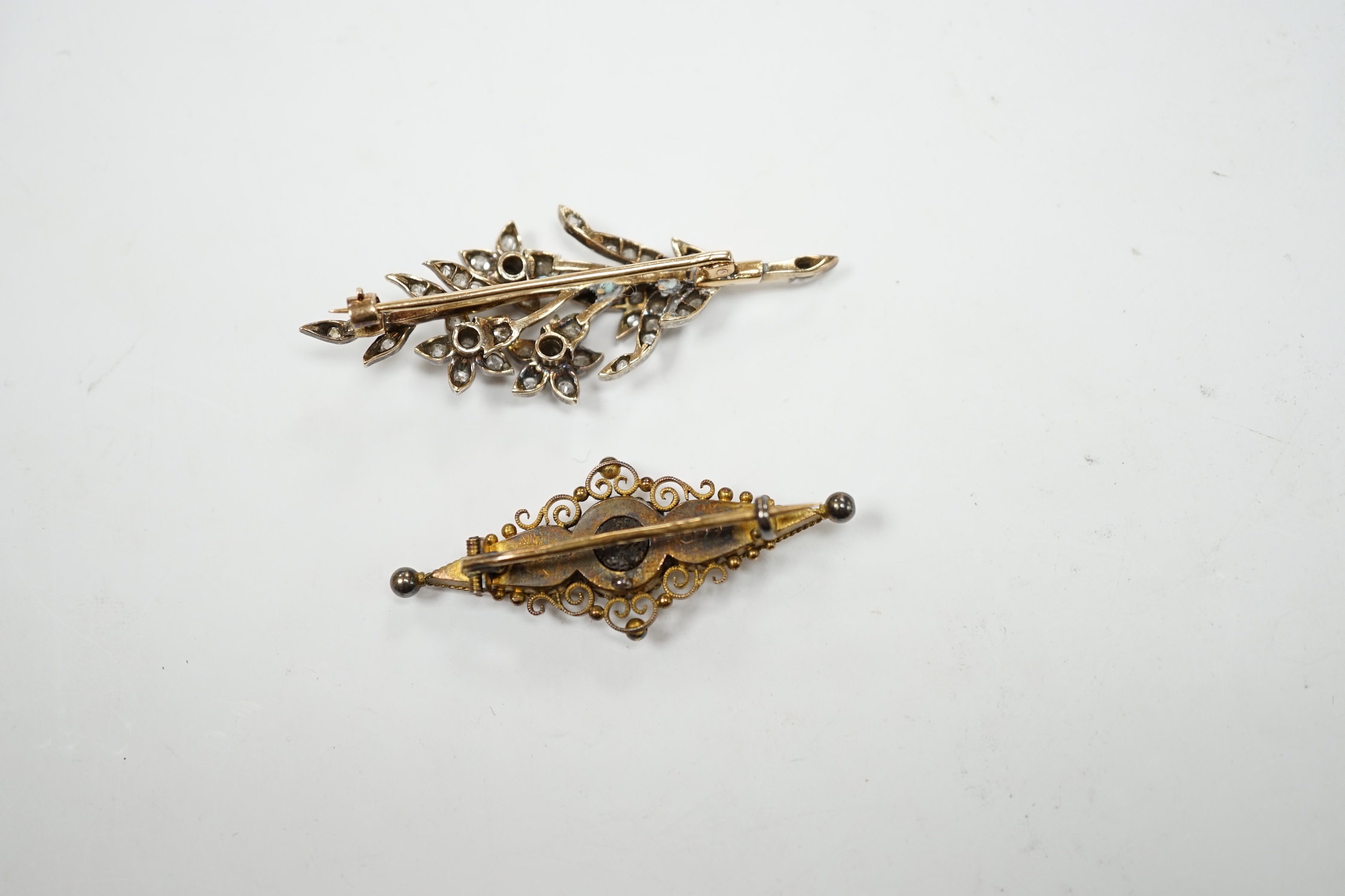 A late Victorian, yellow metal, white metal and diamond cluster set foliate spray brooch, 53mm, together with a Victorian 15ct gold and singe stone diamond set bar brooch, gross weight 11.5 grams.